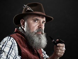 Image showing dramatic portrait of senior smoking tobacco pipe