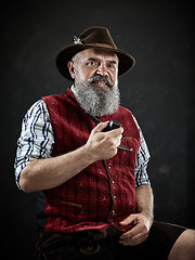 Image showing dramatic portrait of senior smoking tobacco pipe