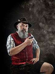 Image showing dramatic portrait of senior smoking tobacco pipe