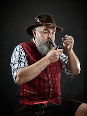 Image showing Black and white dramatic portrait of senior smoking tobacco pipe