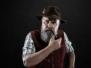 Image showing dramatic portrait of senior smoking tobacco pipe