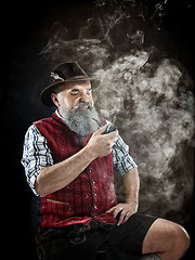 Image showing dramatic portrait of senior smoking tobacco pipe