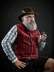 Image showing dramatic portrait of senior smoking tobacco pipe