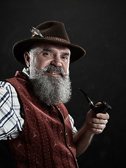 Image showing dramatic portrait of senior smoking tobacco pipe