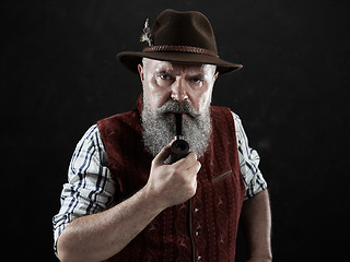 Image showing dramatic portrait of senior smoking tobacco pipe