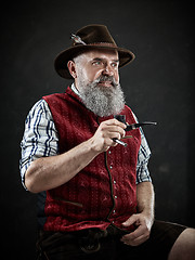 Image showing dramatic portrait of senior smoking tobacco pipe