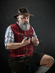 Image showing dramatic portrait of senior smoking tobacco pipe