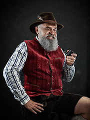 Image showing dramatic portrait of senior smoking tobacco pipe