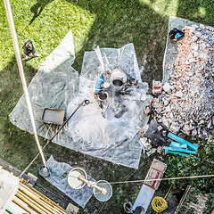 Image showing Top view of authentic builder men working with shovel during concrete cement solution mortar preparation in mixer at construction site