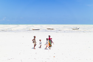 Image showing Paje, Zanzibar - Feb 9, 2015: Local kids walking at Paje village picture perfect white beach at low tide on February 9th, 2015 on Zanzibar, Tanzania