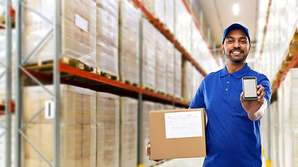 Image showing delivery man with smartphone and box at warehouse