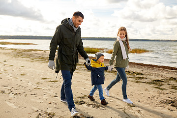 Image showing happy family walking along autumn beach