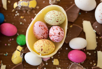 Image showing chocolate egg and candy drops on wooden table