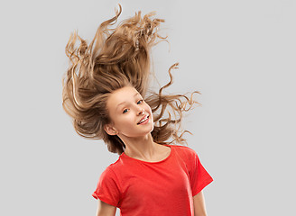 Image showing smiling teenage girl in red with long wavy hair