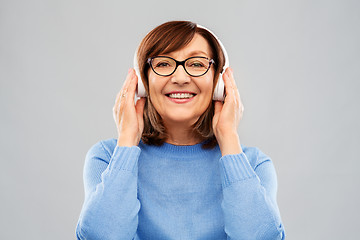 Image showing senior woman in headphones listening to music