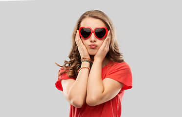 Image showing girl in red heart shaped sunglasses pouting