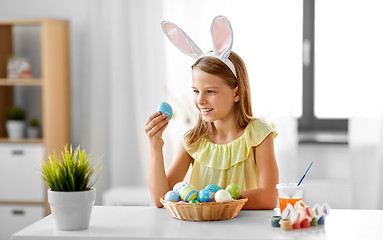 Image showing happy girl with colored easter eggs at home