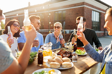 Image showing happy friends with drinks or bbq party on rooftop