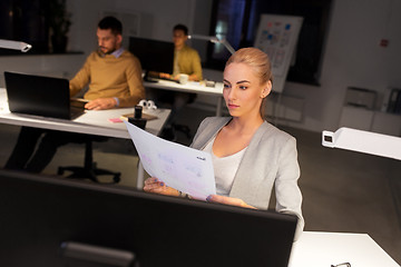 Image showing designer working with papers at night office
