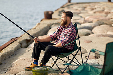 Image showing happy friends with fishing rods on pier