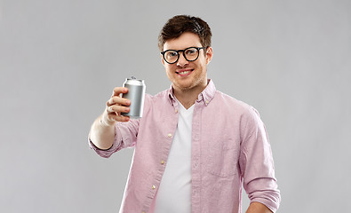 Image showing happy young man drinking soda from tin can