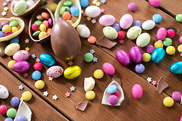 Image showing chocolate eggs and candy drops on wooden table