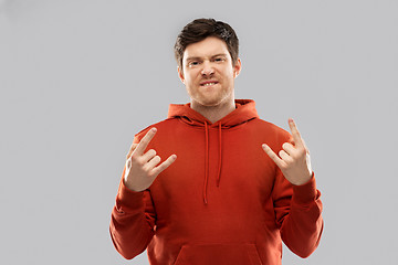 Image showing young man in red hoodie showing rock sign