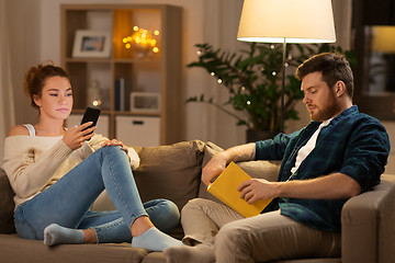 Image showing couple with smartphone and book at home