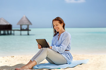 Image showing happy smiling woman with tablet pc on summer beach