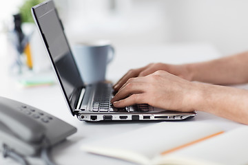 Image showing hands typing on laptop computer at office