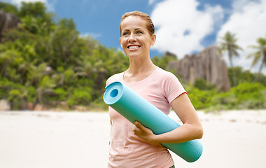 Image showing happy smiling woman with exercise mat over beach