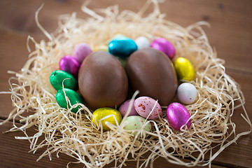 Image showing chocolate eggs in foil wrappers in straw nest