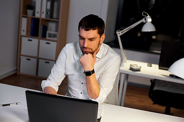 Image showing businessman with laptop working at night office