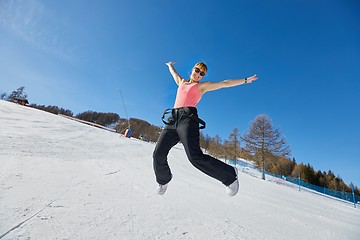 Image showing Woman jumping on a ski track in sunlight