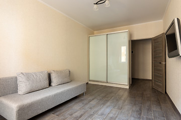 Image showing Interior of a small hotel room, TV, wardrobe and sofa