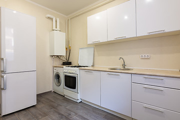 Image showing Fragment of the interior of a small kitchen with a fridge and a kitchen set