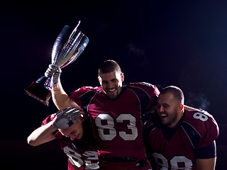 Image showing american football team with trophy celebrating victory