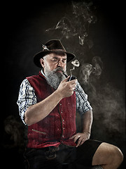Image showing dramatic portrait of senior smoking tobacco pipe