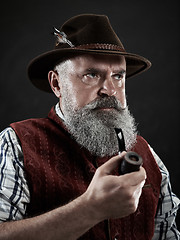 Image showing dramatic portrait of senior smoking tobacco pipe