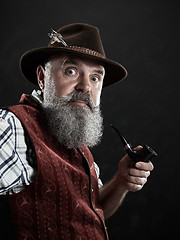 Image showing dramatic portrait of senior smoking tobacco pipe