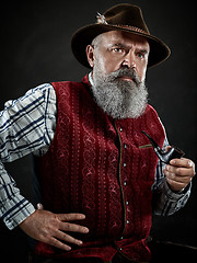 Image showing dramatic portrait of senior smoking tobacco pipe