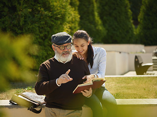 Image showing Portrait of young girl embracing grandfather at park