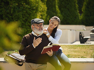 Image showing Portrait of young girl embracing grandfather at park