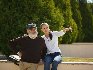 Image showing Portrait of young girl embracing grandfather at park