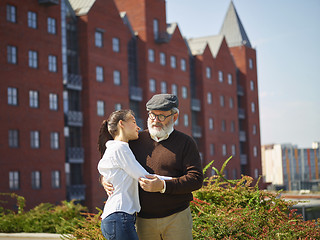 Image showing Portrait of young girl embracing grandfather at park