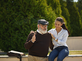 Image showing Portrait of young girl embracing grandfather at park