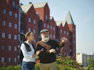 Image showing Portrait of young girl embracing grandfather at park