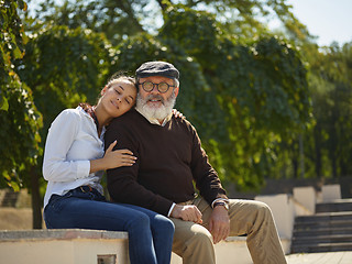 Image showing Portrait of young girl embracing grandfather at park