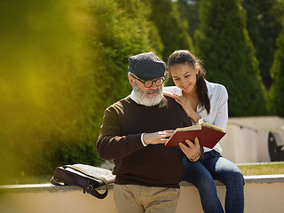 Image showing Portrait of young girl embracing grandfather at park