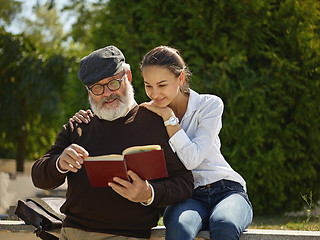 Image showing Portrait of young girl embracing grandfather at park